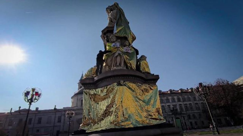 Attivisti di Extinction Rebellion coprono la statua di Camillo Cavour a Torino per denunciare la crisi climatica e le diseguaglianze sociali