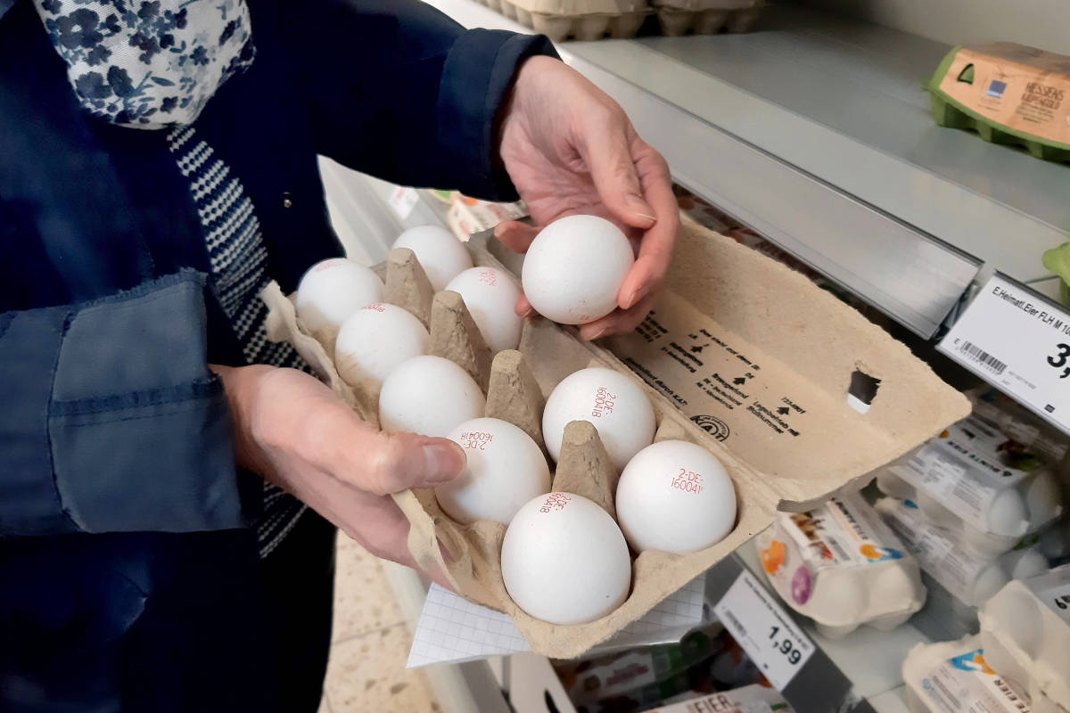 Un americano ride davanti alle uova in un supermercato Edeka in Germania