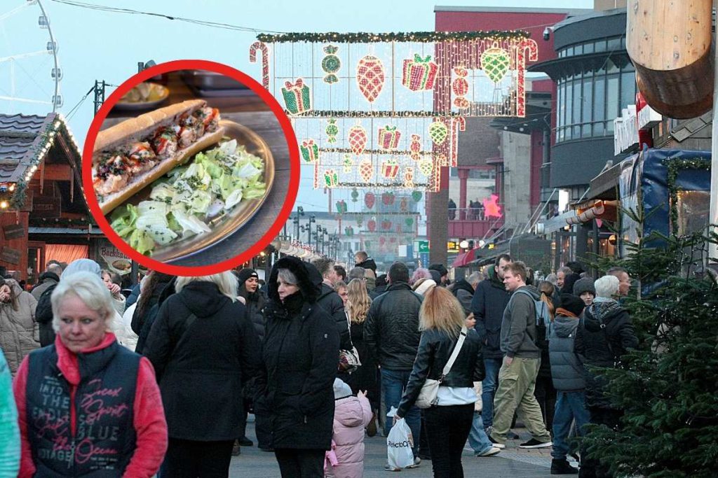 Abitante di Amburgo prova il pesce al mercato di Natale del centro